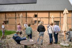 (Satemin) 13.09.25; Tag des offenen Denkmals 2025. Fuehrung/Gespraech mit Maurermeister Ruben Heindrichs (im Bild mitte links) und David Feldbruegge vom Lehm-Laden (m/r). Alte Scheune Satemin Rundling Satemin